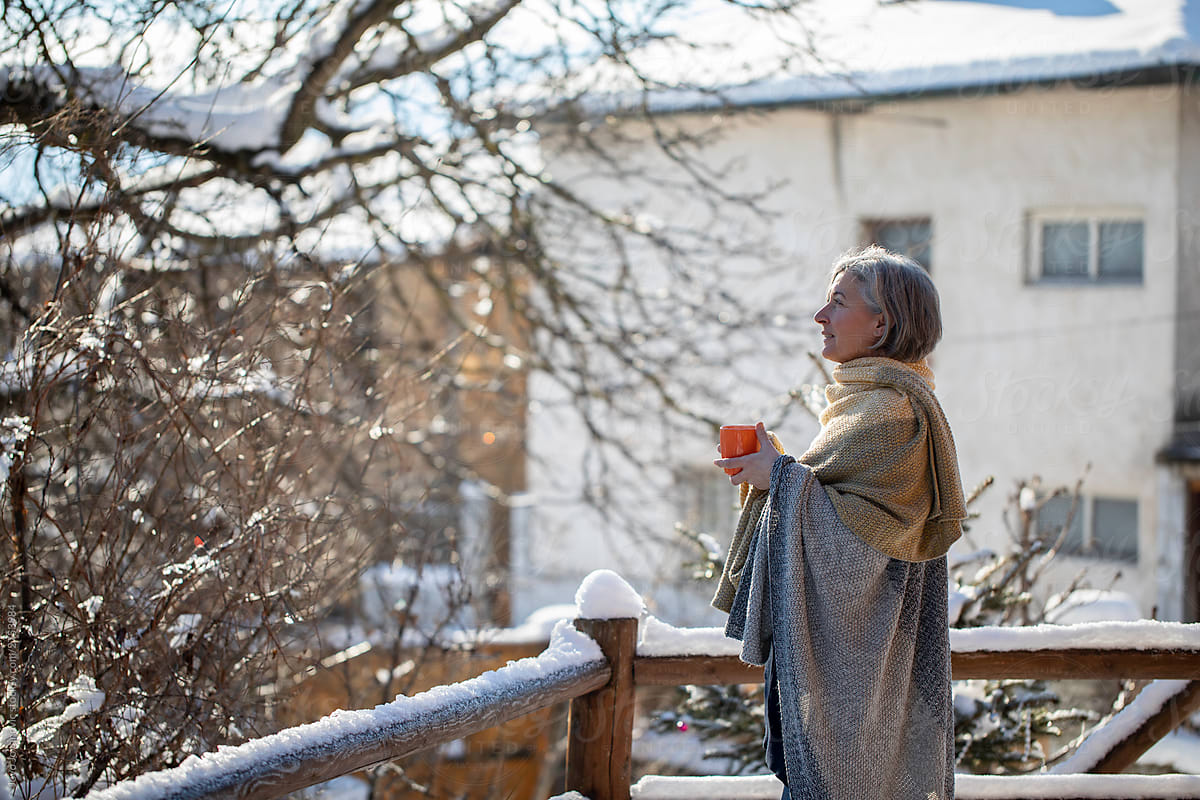 Older woman enjoying nature while holding hot cup