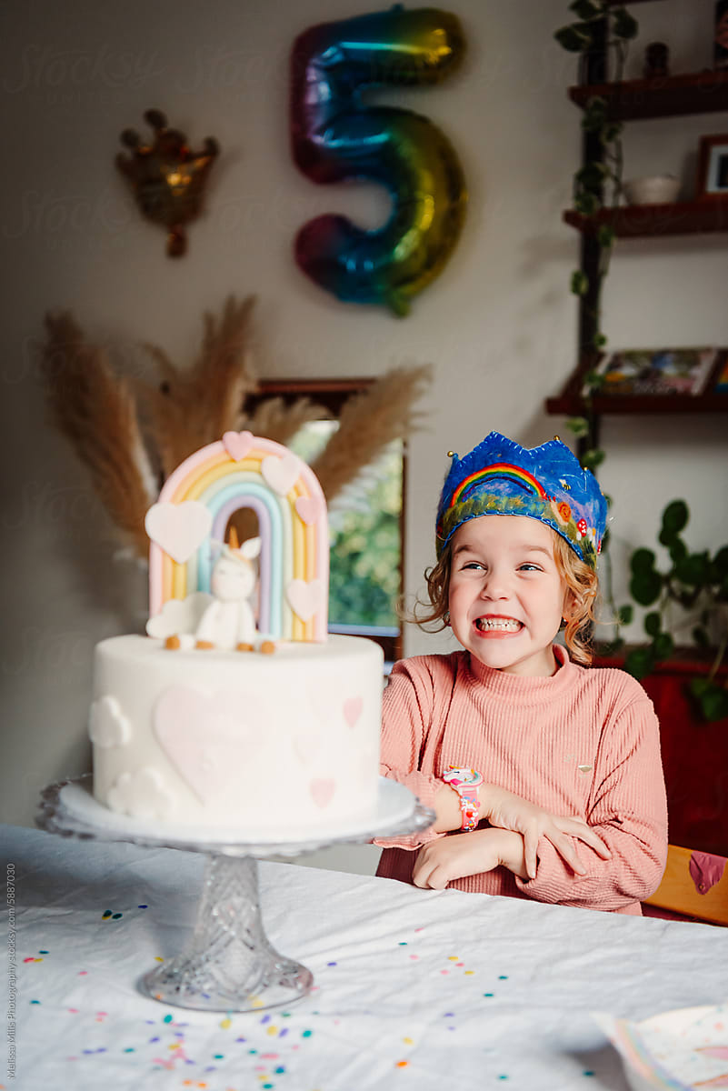 Birthday girl with her unicorn and pastel rainbow themed bday cake