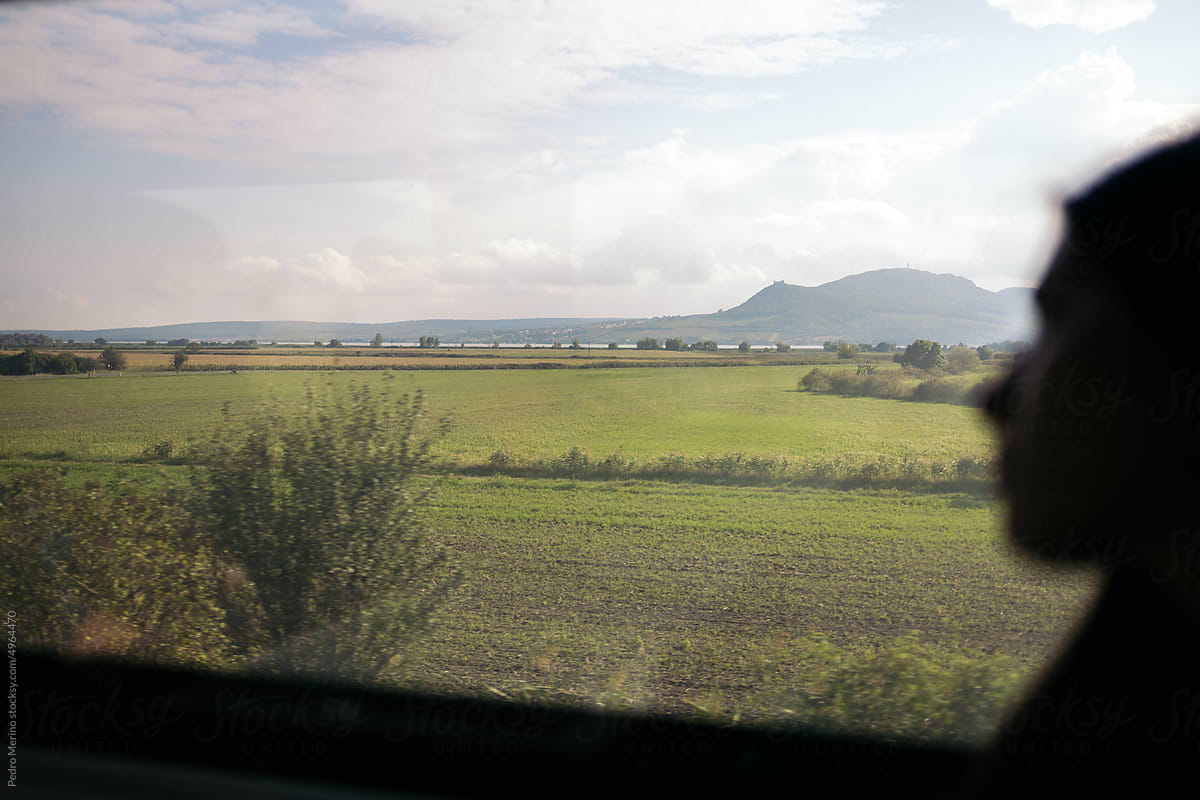 Woman watching a beautiful landscape through the train window