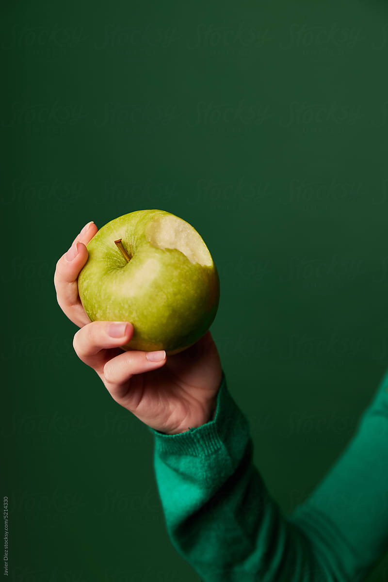 Crop woman holding green apple