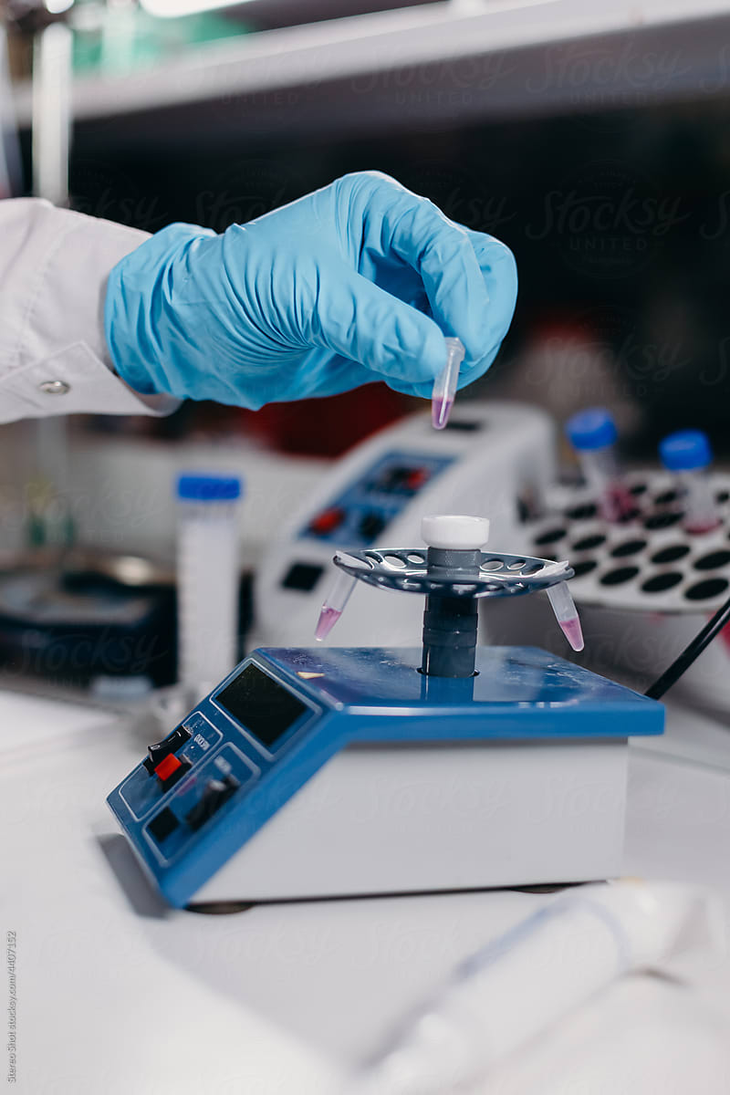 Scientist putting sample in lab centrifuge