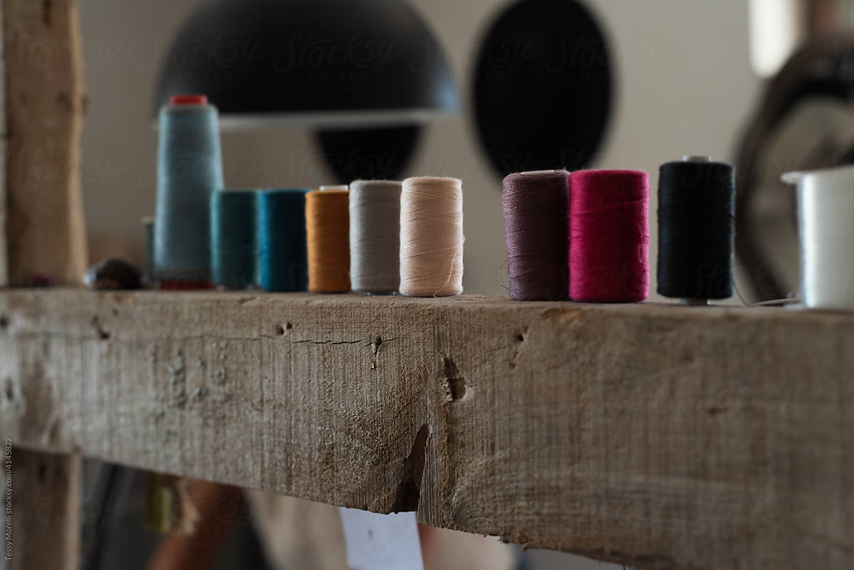 Rough wooden beam with multicolour spools of thread