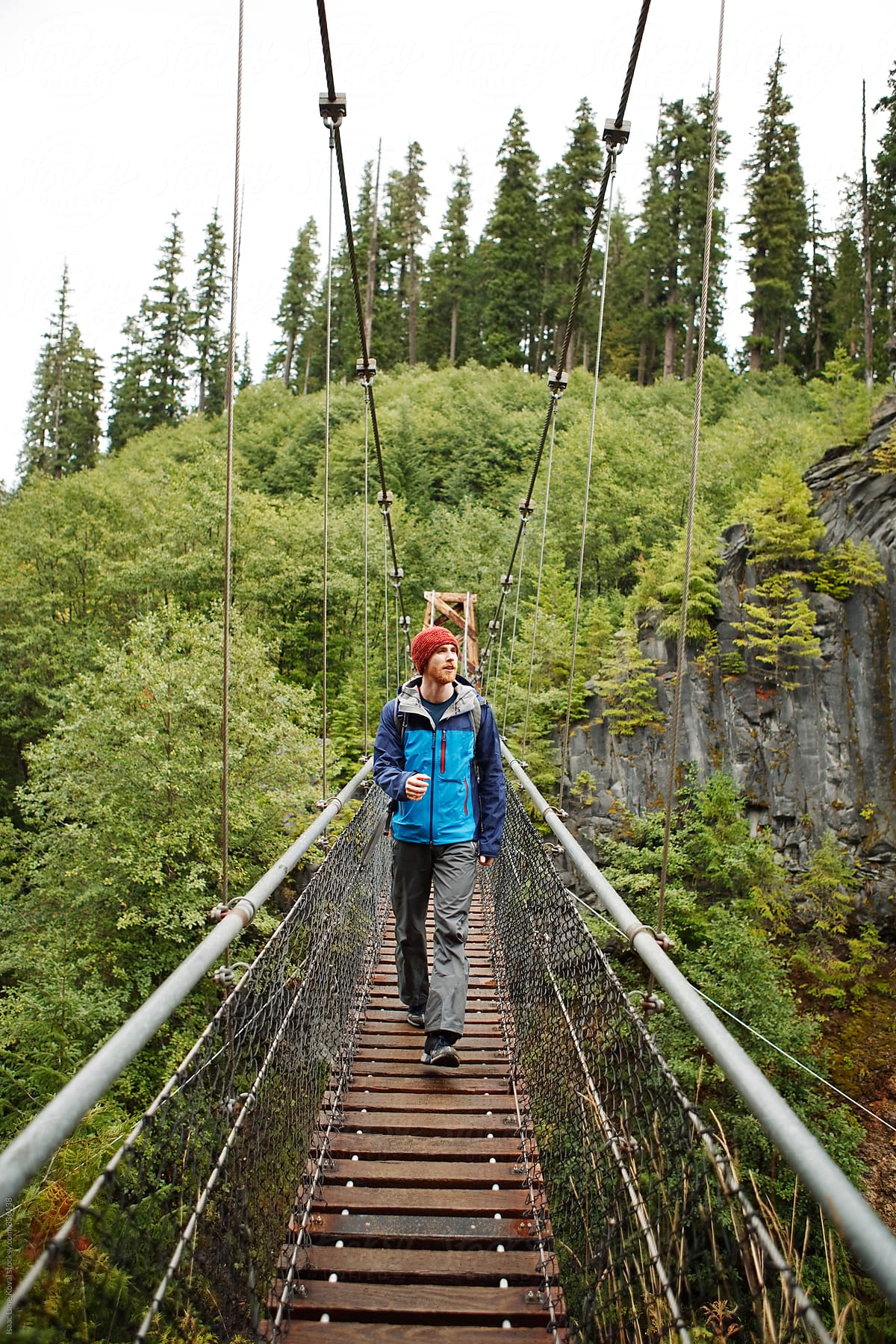 Man walking across suspension bridge