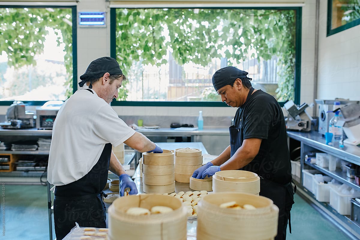 Two cooks preparing bamboo steamers for next service.