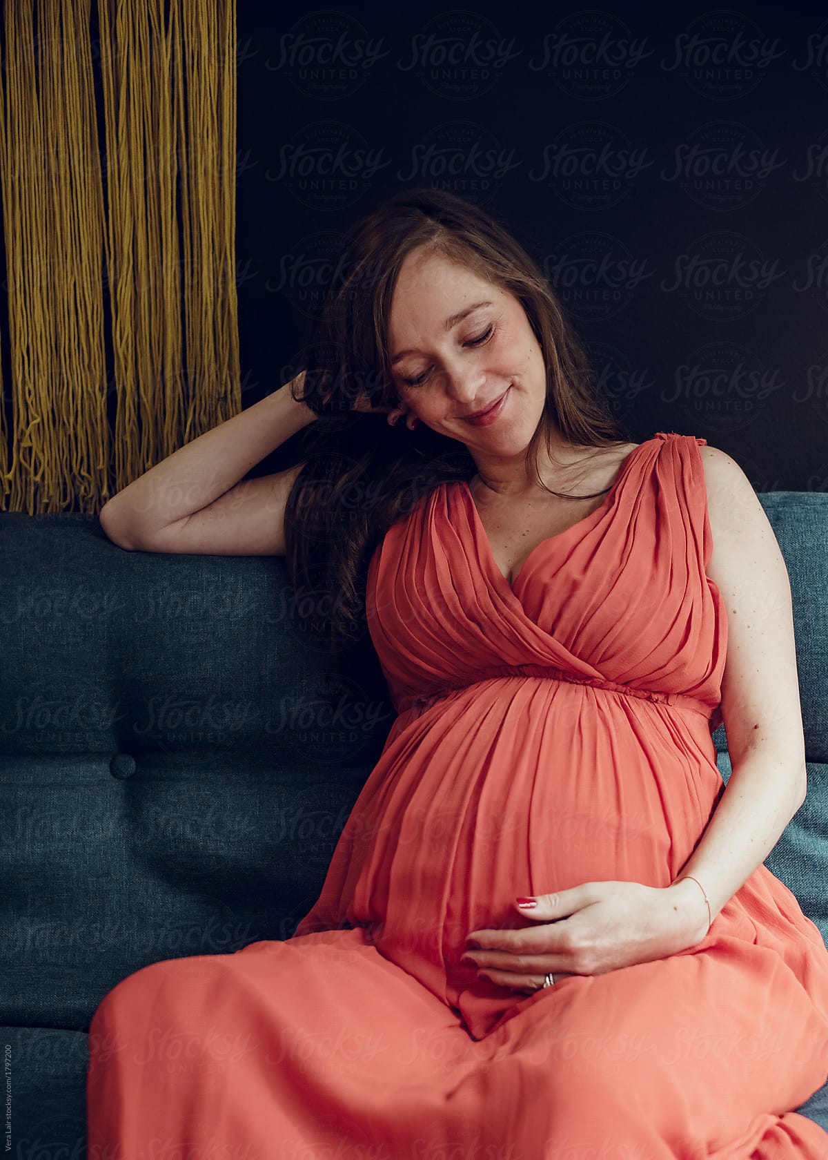 Pregnant Woman Sitting On A Sofa By Stocksy Contributor Vera Lair