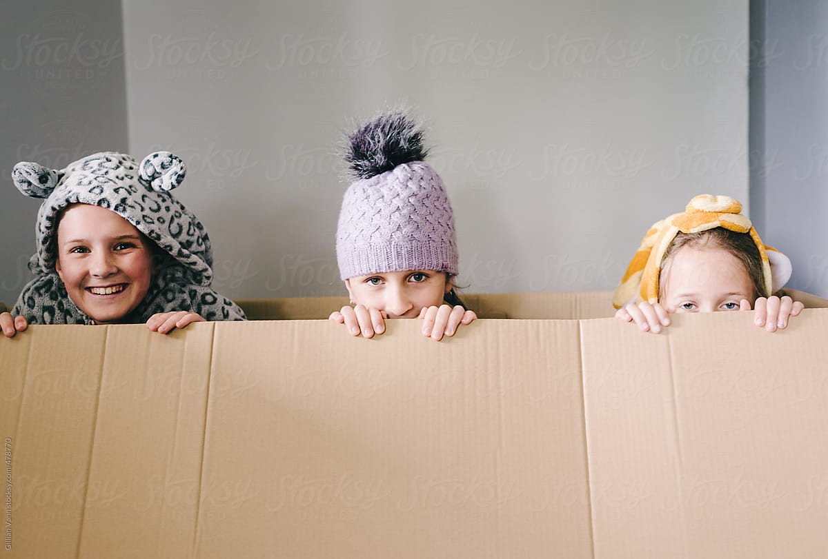 Three Children Playing In An Empty Cardboard Box