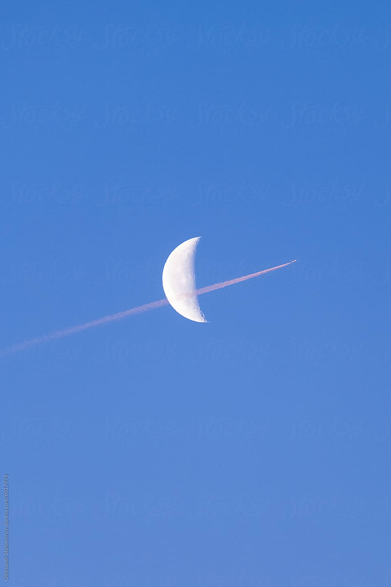 Moon and airplane on morning sky.