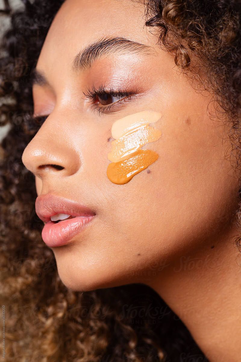 Testing makeup foundation on the skin of a young woman