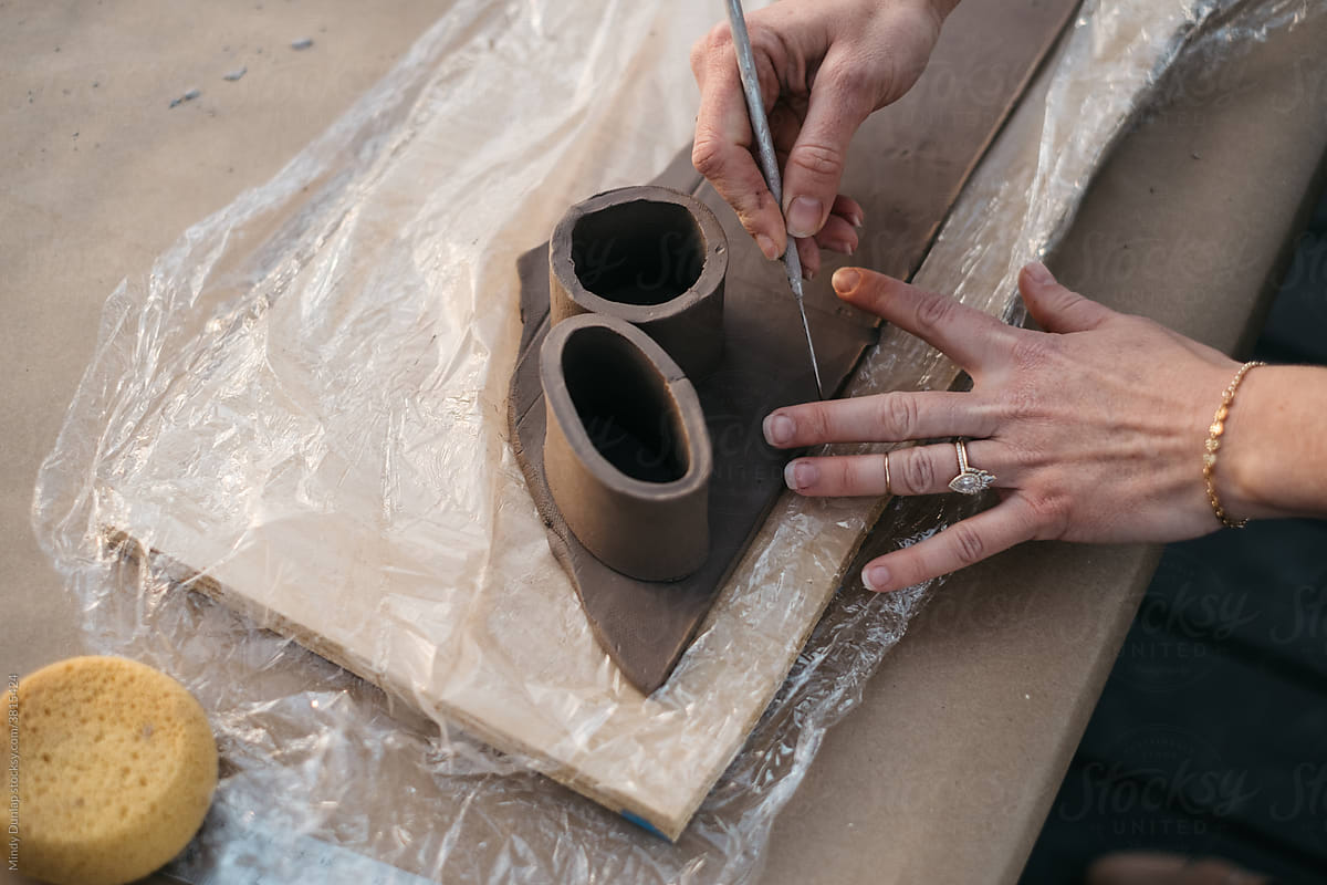 Hands forming a clay vessel for ceramics production