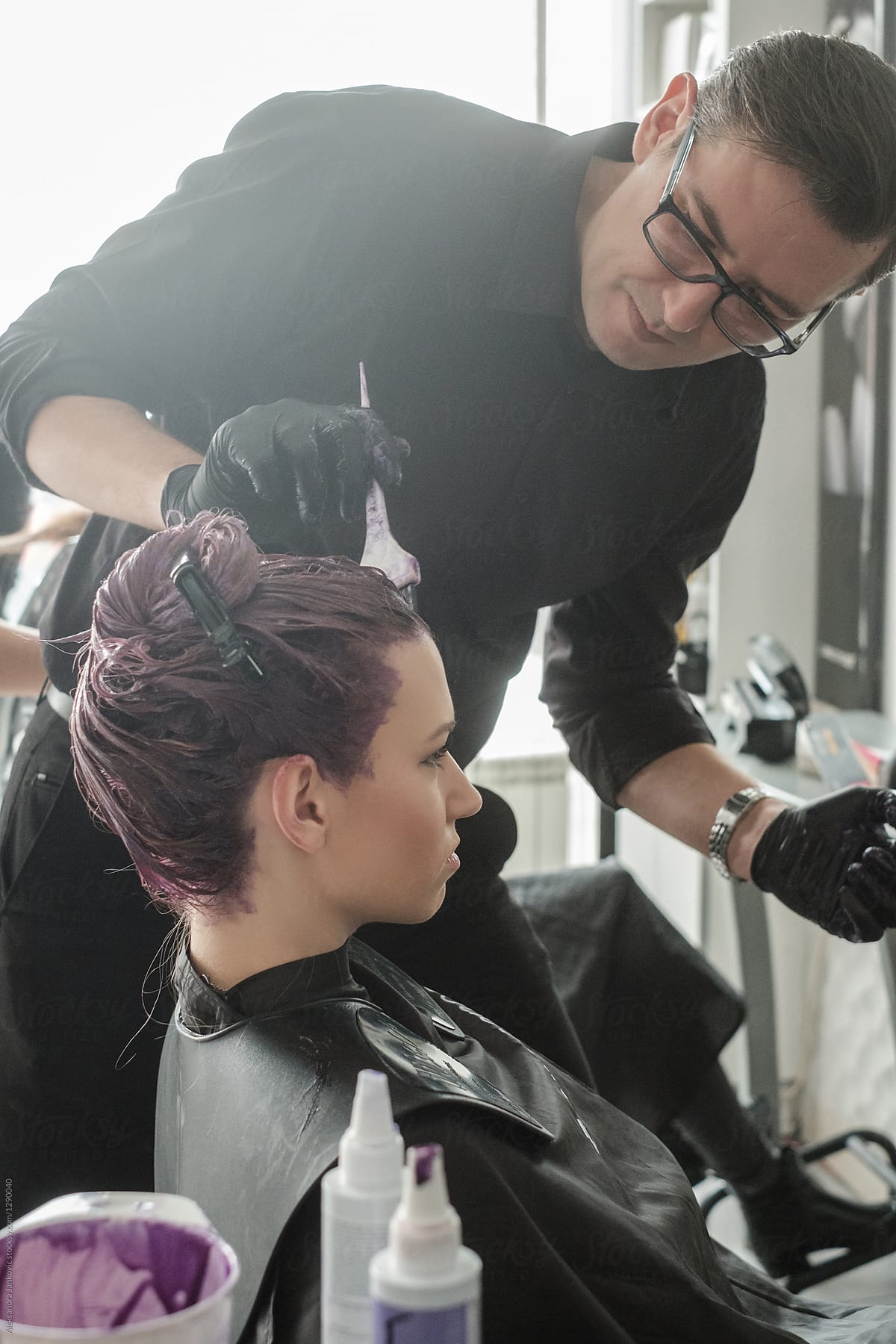 Hairdresser Appying Hair Dye On Customer's Hair In The Salon