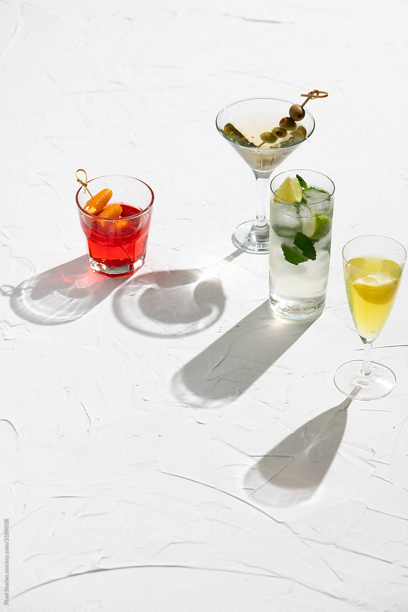 Various colorful alcohol cocktails on white