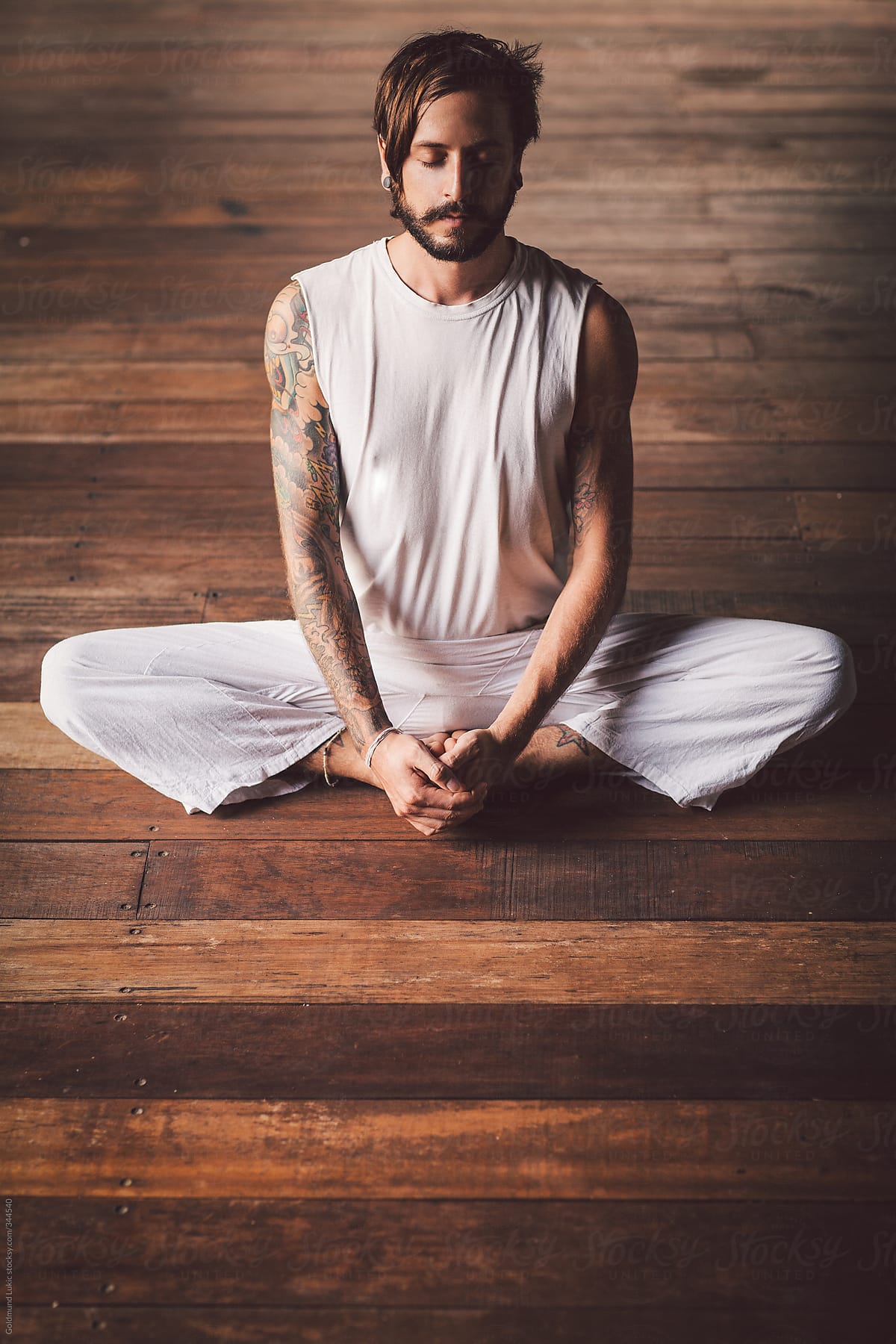 Tattooed Man Sitting in the Throne Yoga Pose (Bhadrasana)