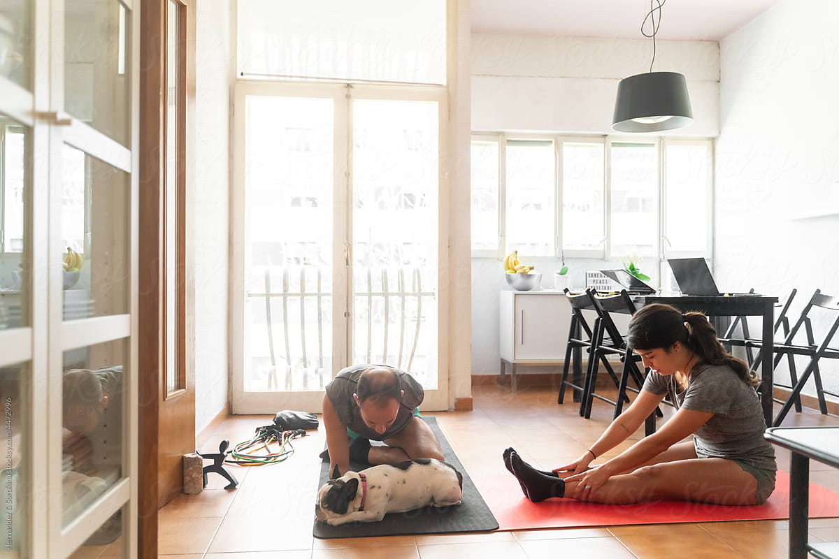 Sporty Couple Performing Yoga In Living Room