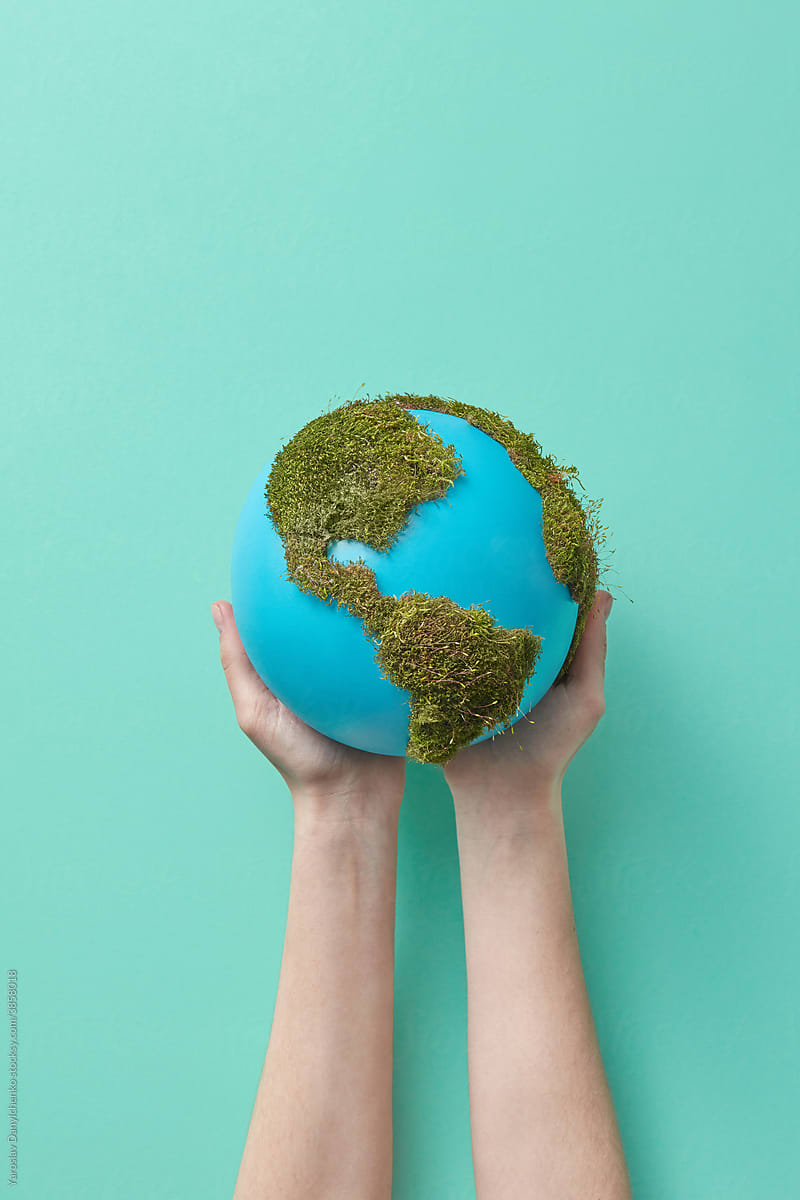 Woman holding earth globe with green moss