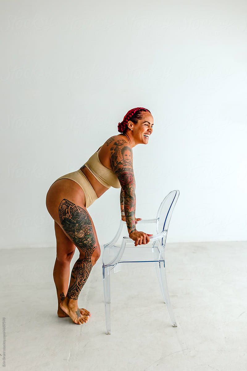 Curvy woman poses with clear chair