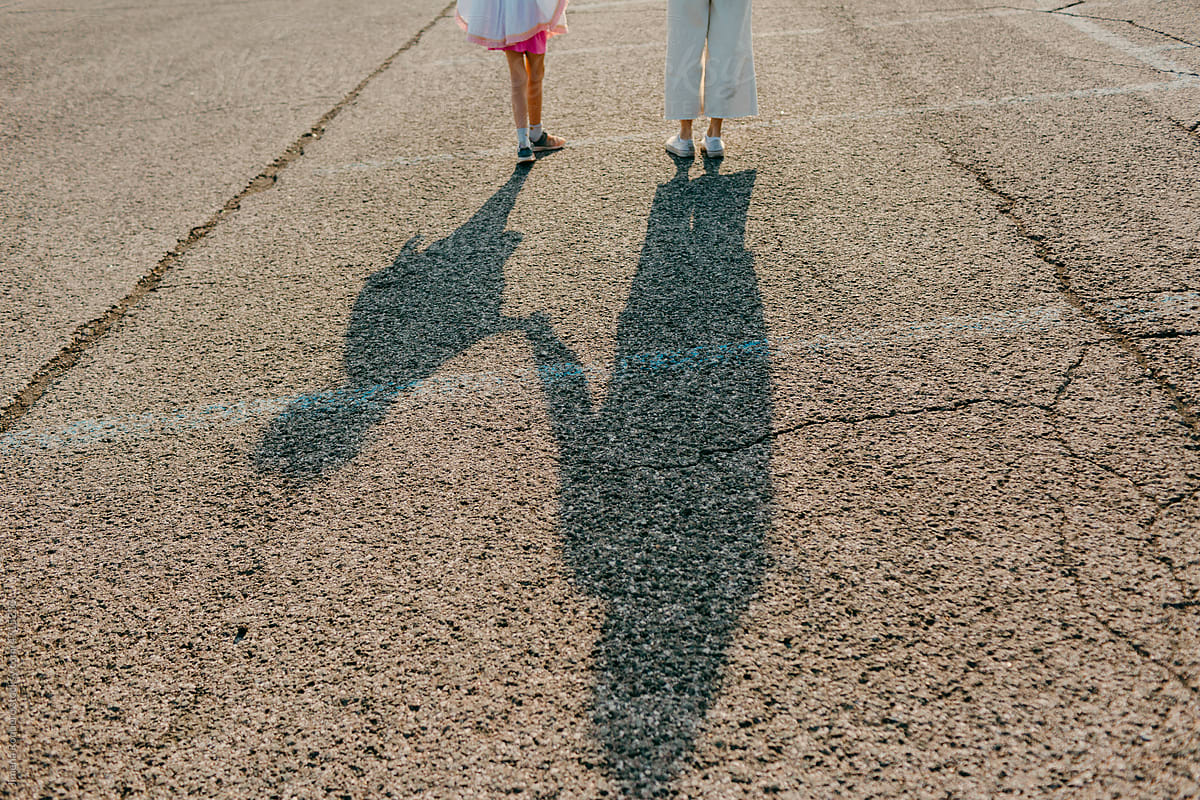 Mother and daughter shadow on asphalt