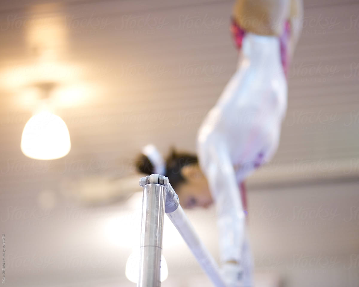 Female Gymnastis Performing Bars Routine