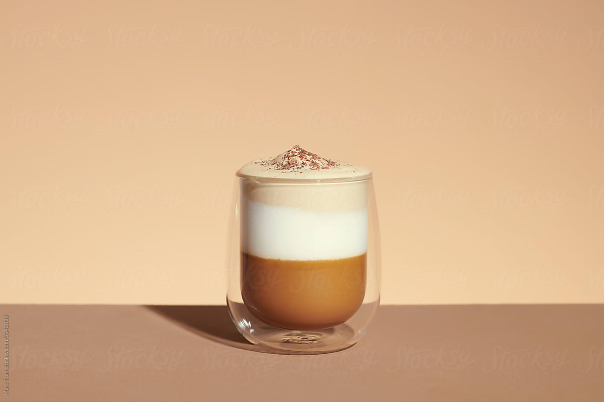 milk latte with coffee foam in glass mug with ingredients