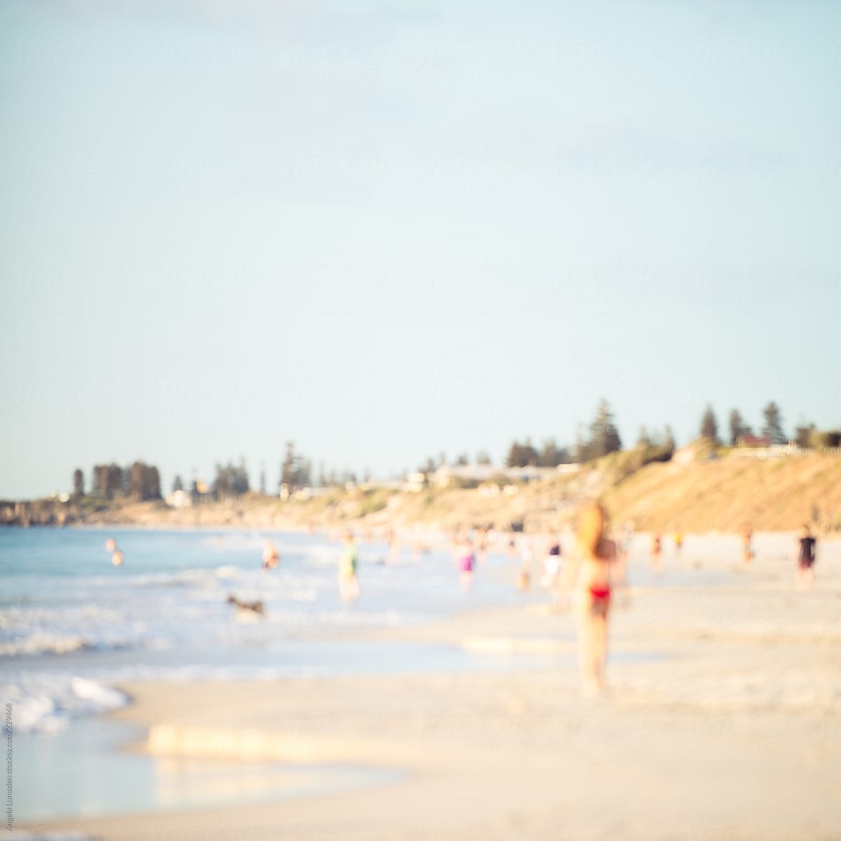 Defocused image of a busy beach in late afternoon