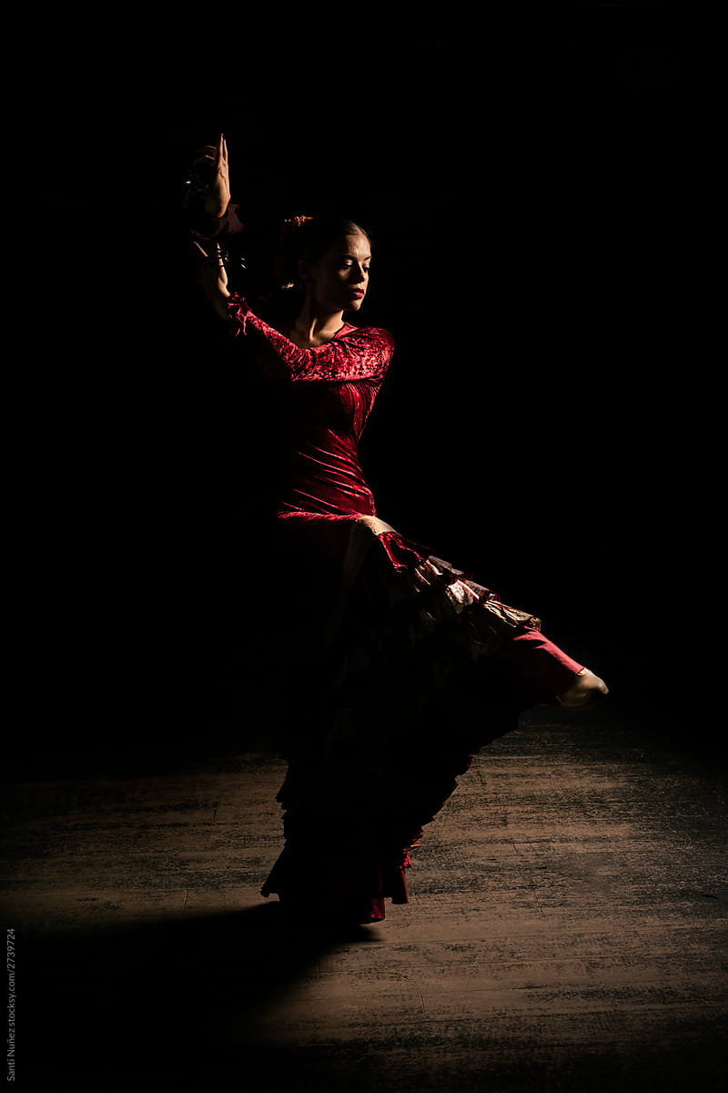 Young woman dancing flamenco on black
