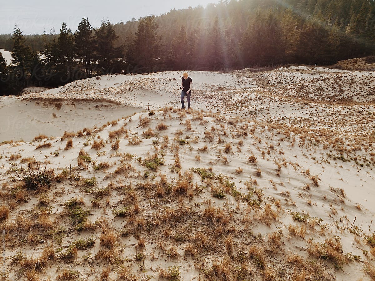 Man on Sand Dunes Surrounded by Forest