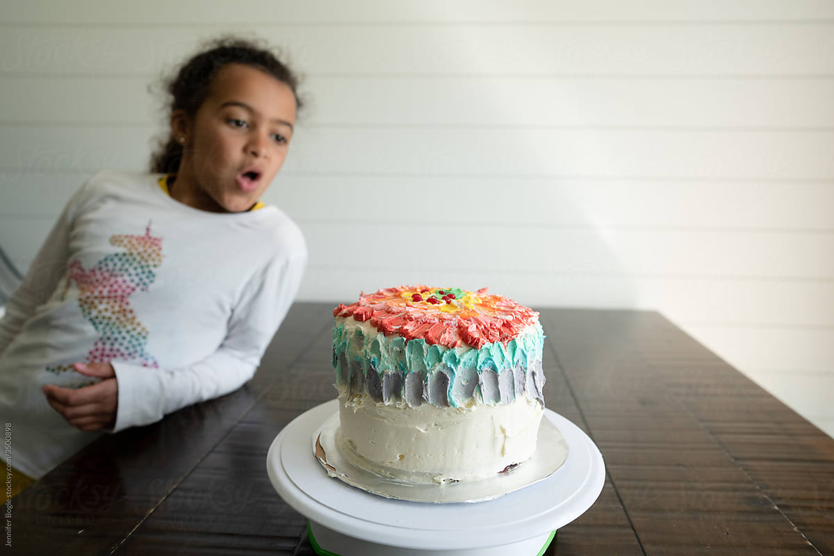 Girl exclaims over frosted layer cake