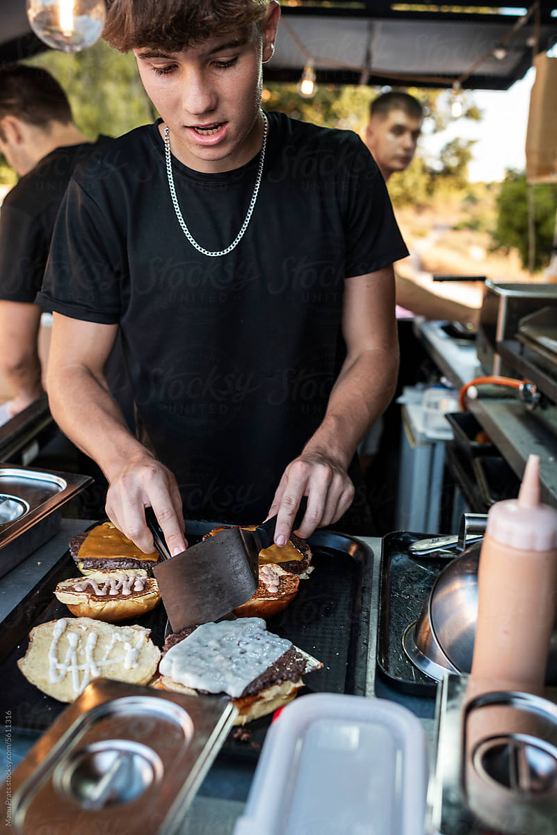 Chef plating smash burgers in a small business food truck