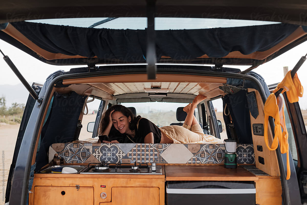 Woman using phone inside camper van