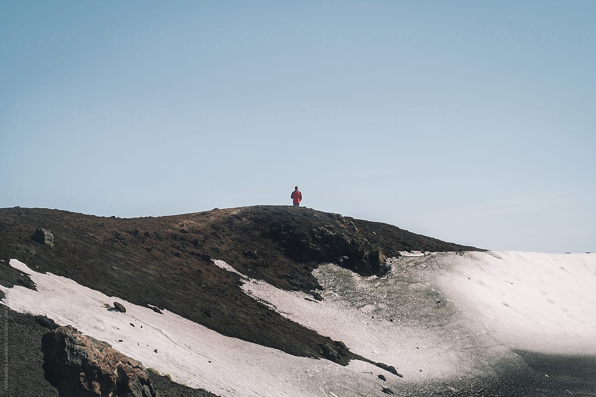 Anonymous person standing alone on the volcano cliff