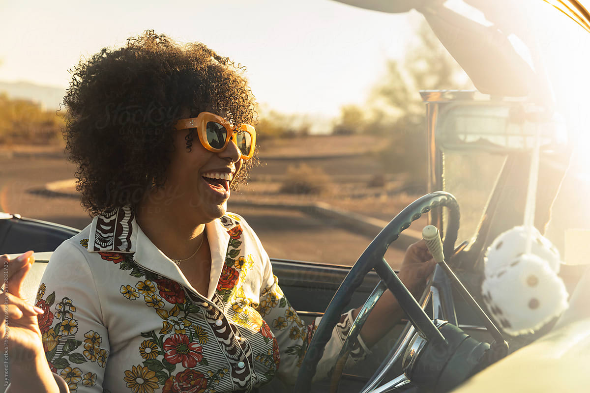Black woman in Vintage Car behind the wheel