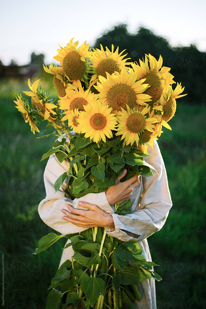 Girl holding a large bouquet of sunflowers