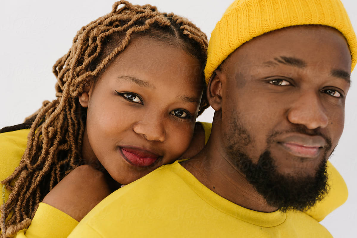 A black couple portrait in yellow outfit looking to the camera