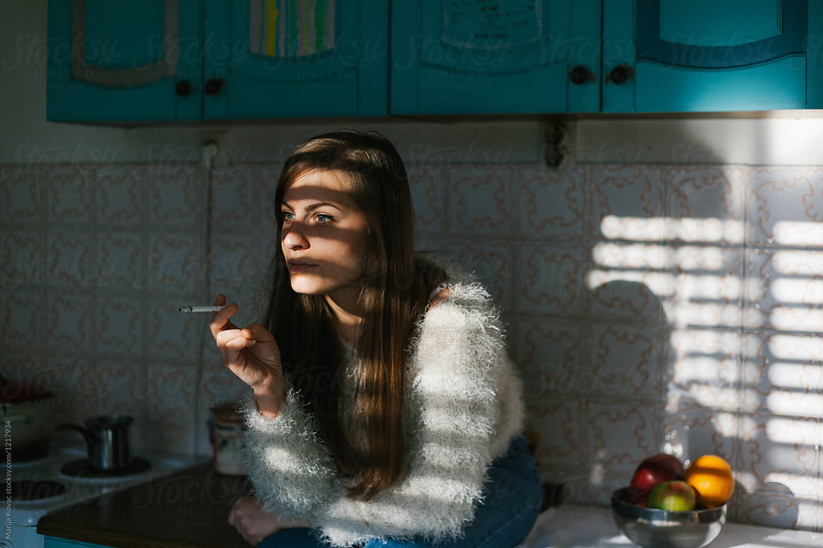 cigarette kitchen A Woman Sitting In The Kitchen Smoking Cigarette