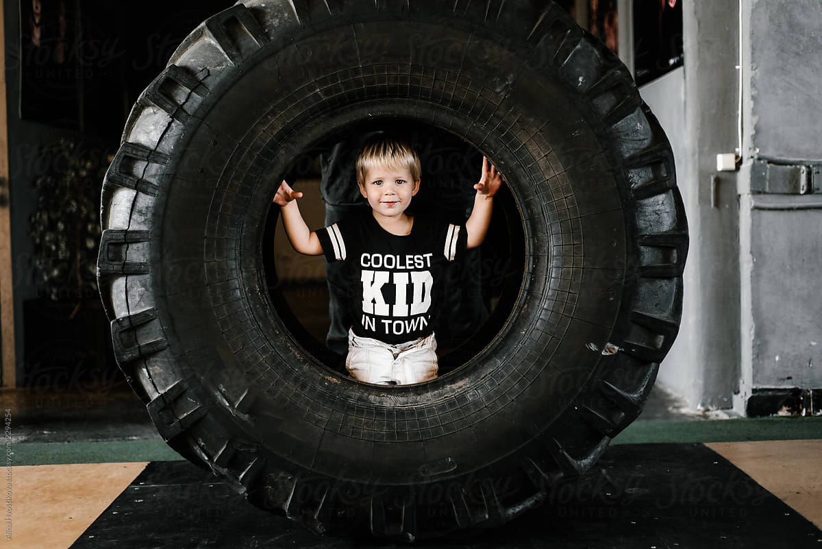 Adorable boy in huge round tire