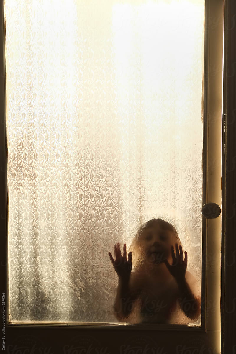 Shadow on a clear glass of a small child