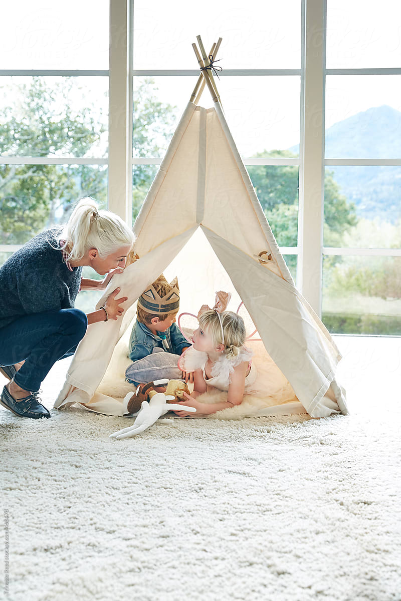 Mom and kids playing in teepee tent in living room