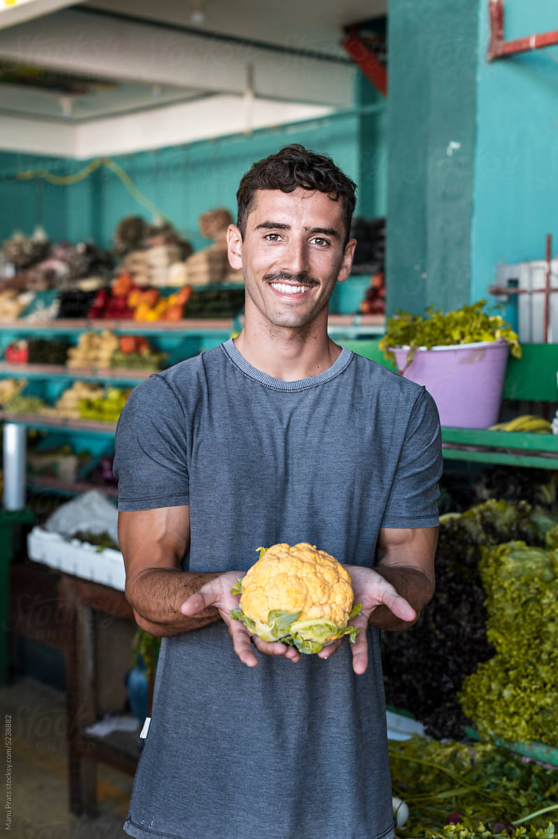 Man buying yellow cauliflower in market