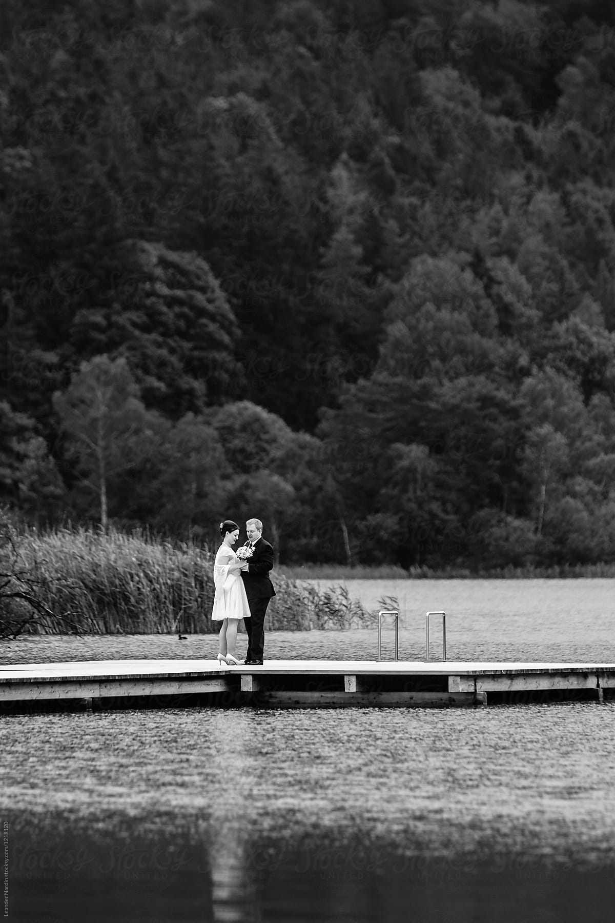 bridal couple standing on a jetty - black and white
