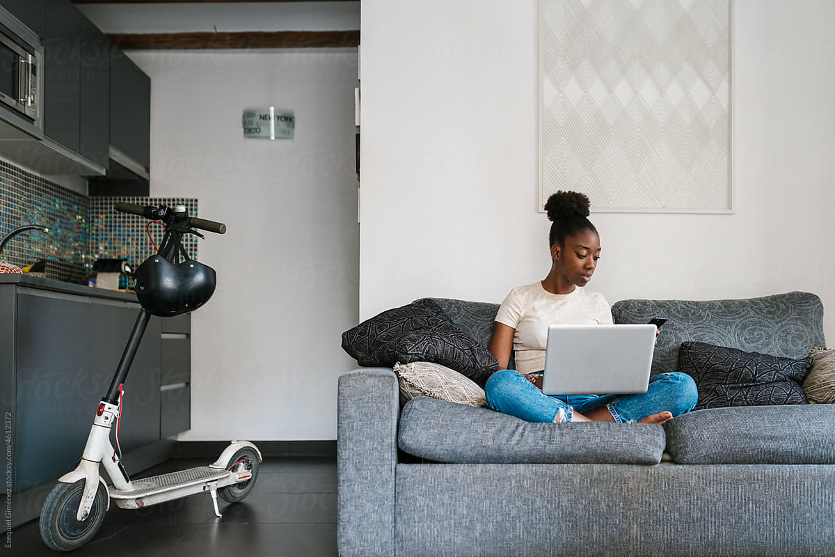 Young African American female using gadgets at home