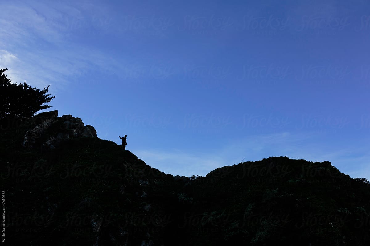 Silhouette of Person Walking along a Ridge