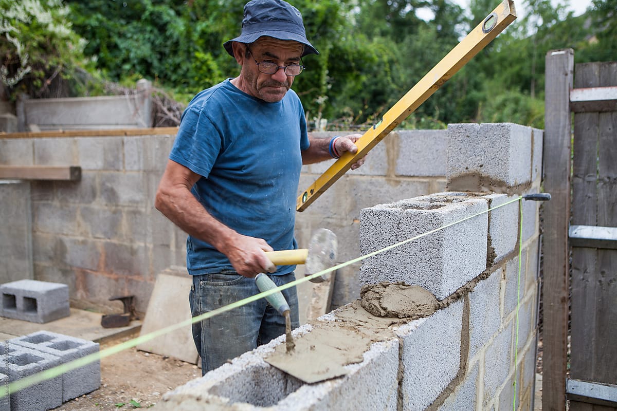 Builder working on a construction site building a wall