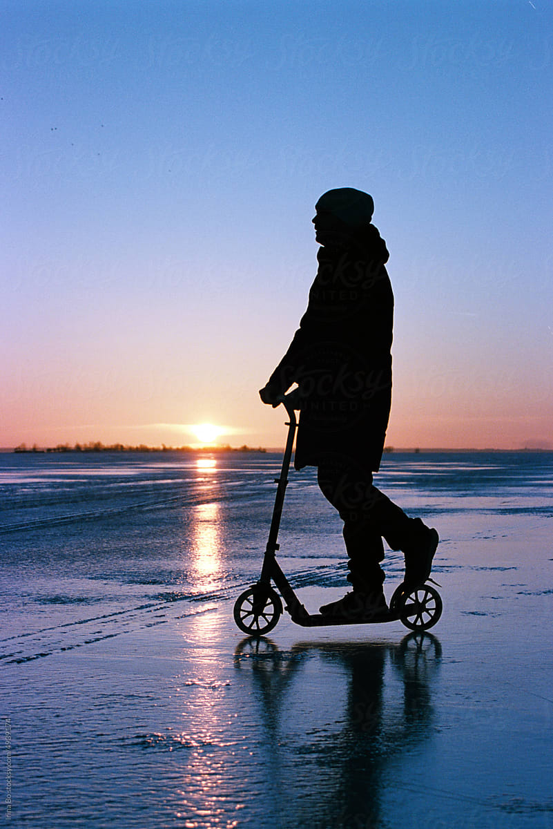 man riding Kick scooter on ice