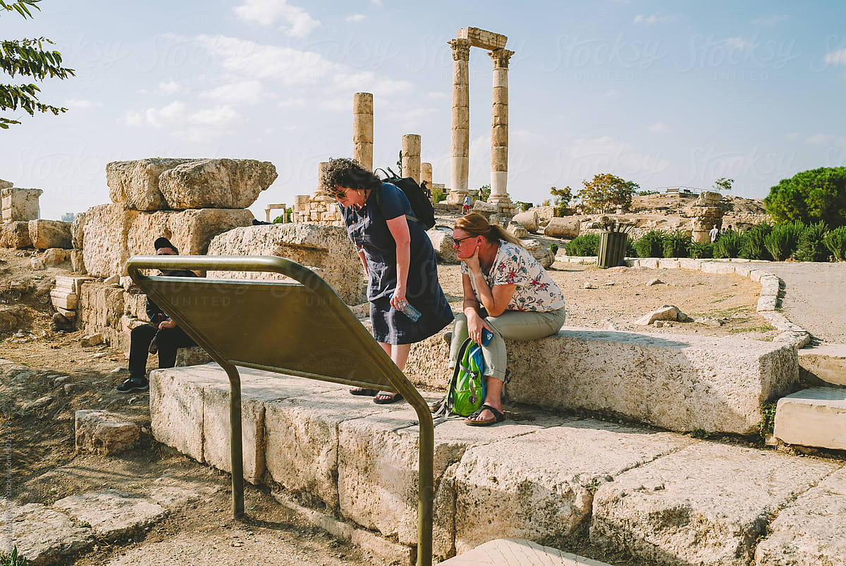 Female tourists consult map at historic site in Amman