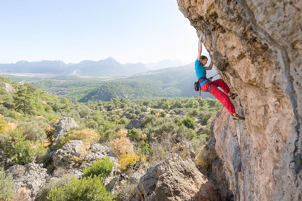 Young woman rock climbing in a wonderful natural landscape
