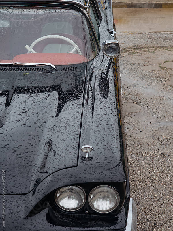 Classic vintage black car covered in water after rain shower