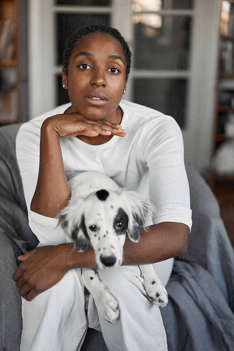 Cute black woman sitting on a chair with her dog