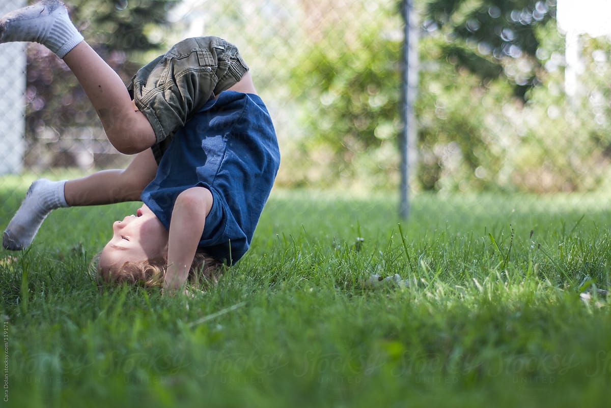 "Young Boy Is In Mid-somersault While Playing Outside In His Yard" by ...