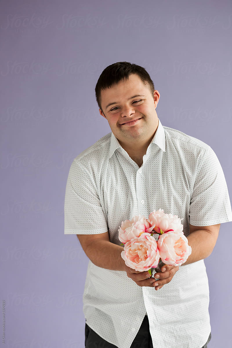 Portrait Of Handsome Young Man With Down Syndrome By Stocksy