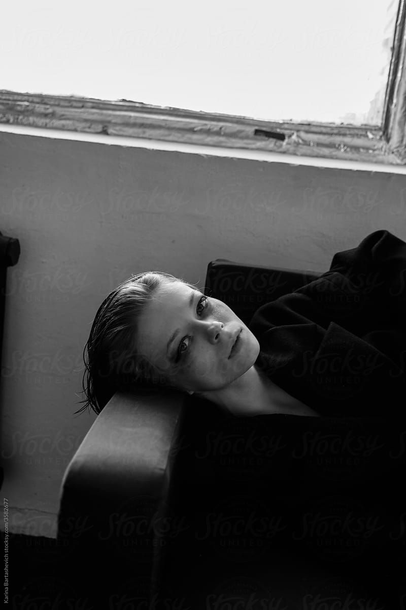 black and white art portrait of a girl lying on a sofa with blurry eyes