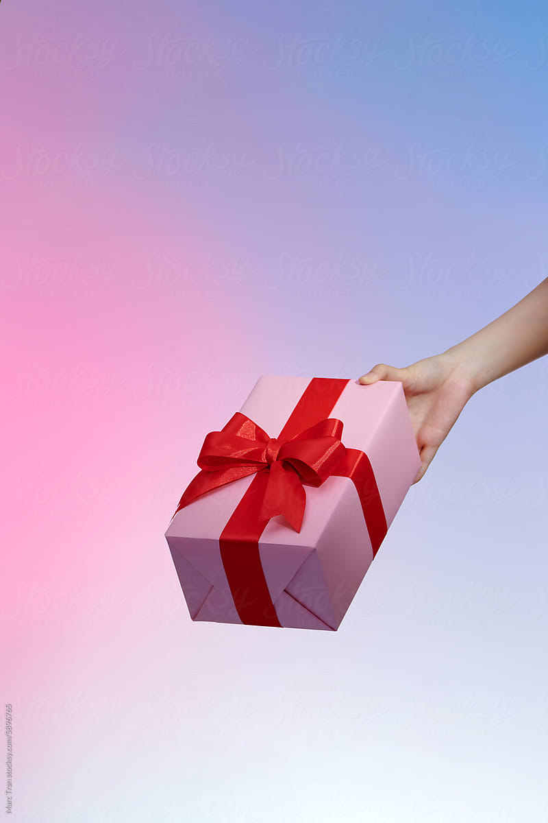 Gift box with red ribbon on trendy neon color background.